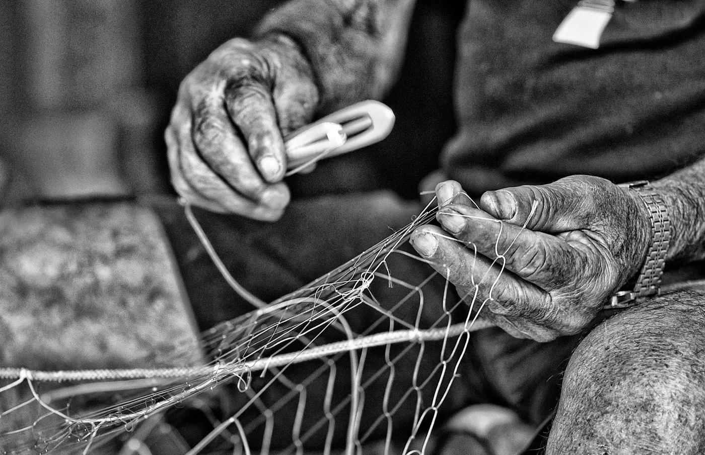 Manos reparando una red de pesca