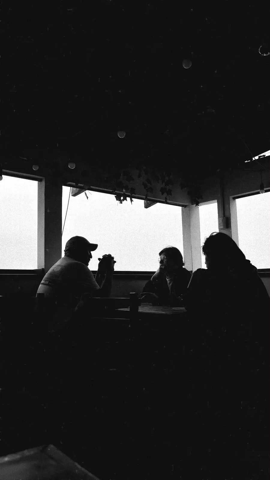 Siluetas observando el mar desde un espacio cubierto